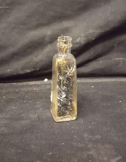 Vial full of Sequence sewn to string