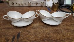 White tea cups and saucers with golden accents