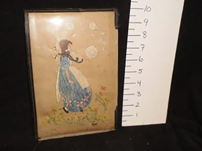 Embroidered picture in cardboard frame.