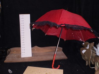Red parasol with black lace trim, curved handle